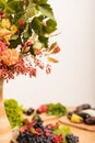 Autumn composition vase, berries, fruits, vegetables on the table in the kitchen