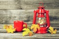 Autumn composition with vintage oil lamp, coffee cup and autumn leaves