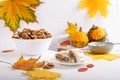 Autumn composition with walnuts , pumpkins, delicious apple strudel and colorful fall leaves on white background. Copy space.