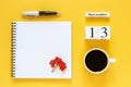 Calendar November 13 cup of coffee, notepad with pen and yellow leaf on yellow background