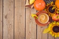 Autumn concept with coffee cup, pumpkin, apples and sunflowers on wooden table. Thanksgiving holiday background. Top view from Royalty Free Stock Photo