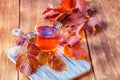 Autumn concept drink warm morning tea, healthy natural infusion of raspberry leaves for herbal therapy on a wooden background.