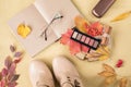 Autumn concept: a palette of autumn paints in a stick of shadows shade nude for makeup, beige women `s boots, a notebook for