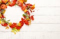 Autumn concept with pumpkins, flowers, autumn leaves and  rowan berries on a white rustic background. Festive autumn decor, flat Royalty Free Stock Photo