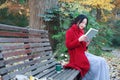 Young asian sensual woman reading a book sit bench in romantic autumn scenery.Portrait of pretty young girl in autumnal forest Royalty Free Stock Photo