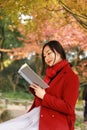 Young asian sensual woman reading a book in romantic autumn scenery.Portrait of pretty young girl in autumnal forest