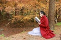 Young asian sensual woman reading a book in romantic autumn scenery.Portrait of pretty young girl in autumnal forest Royalty Free Stock Photo