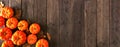 Autumn corner border banner of pumpkins and fall leaves, top view over a rustic wood background Royalty Free Stock Photo