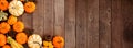 Autumn corner border of pumpkins, gourds and pine cones on a rustic dark wood banner background Royalty Free Stock Photo