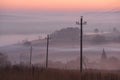 Autumn country landscape. Power line in fog in sunrise