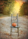 Autumn Country Road with Pumpkin on Rustic Chair. Royalty Free Stock Photo