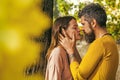 Autumn couple in love of happy man and woman kiss with yellow tree leaves in park outdoor, love and relations. Royalty Free Stock Photo