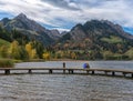 Autumn, couple sitting on the shore Lake Schwarzsee