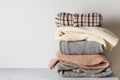 Autumn cozy and casual clothes stack close up on table on white background