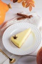 Autumn cozy image with pumpkin pie piece on white plate on napkin on white wooden table. Royalty Free Stock Photo