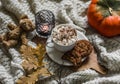 Autumn cozy still life - cocoa with marshmallow, chocolate cookies, yellow oak leaves branch, teddy bear toy, candle on a cozy