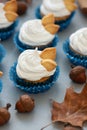 Autumn cupcakes decorated with cream and cookies leaves on gray wooden background. Soft focus. Thanksgiving day or Halloween Royalty Free Stock Photo