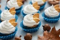 Autumn cupcakes decorated with cream and cookies leaves on gray wooden background. Soft focus. Thanksgiving day or Halloween Royalty Free Stock Photo