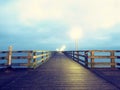 Autumn dark mist on wooden pier above sea. Depression, dark atmosphere.