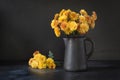 Autumn dark still life. Fall with yellow chrysanthemum flowers in clayware vase on black.