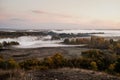 autumn dawn, fog in the field above the trees Royalty Free Stock Photo