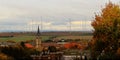 Autumn dawn or sunset above european roofs,trees,Catholic church,wind generators Royalty Free Stock Photo