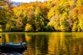 Autumn day, boat in the lake in the autumn forest. Yellow leaves of trees are reflected in the waters of the lake Royalty Free Stock Photo