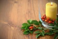 Autumn decoration with rose hips and burning candle in glass Royalty Free Stock Photo