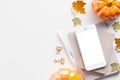 Autumn desk table with pumpkins, maple leaves, smartphone mockup. Blogger workspace top view. Flat lay. Cozy, hygge style