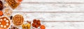 Autumn desserts corner border with assorted traditional fall sweet treats over a white wood banner background