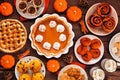 Autumn desserts table scene with an assortment of traditional fall treats, above view on a wood background