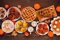 Autumn desserts table scene with a selection of traditional fall treats, overhead view on a wood background