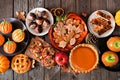 Autumn desserts table scene with a variety of sweet fall treats over dark wood