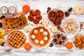 Autumn desserts table scene with a variety of traditional fall sweet treats over white wood