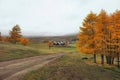 Autumn dirt road from a hill to a remote village Royalty Free Stock Photo