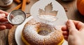 Dusting Powdered Sugar on Autumn Donut with Maple Leaf Stencil Fall Baking Decor Royalty Free Stock Photo