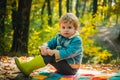 Autumn dream. Cute children with Autumn Leaves on Fall Nature Background. Children sits in the forest and dreams