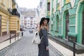 In the autumn dressed woman walks along the streets of the old town. Stylish tourist girl walking in a beautiful town.