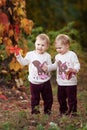 Autumn emotional portrait of little twin girls. Pretty little girls with red grape leaves in autumn park. Autumn activities for Royalty Free Stock Photo