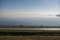 Autumn empty road near the lake and trees. Road on a sunny day in the countryside in Poland Royalty Free Stock Photo