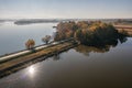 Autumn empty road near the lake and trees. Road on a sunny day in the countryside in Poland Royalty Free Stock Photo