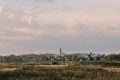 autumn evening landscape with a field and a river and a Christian Church on the horizon Royalty Free Stock Photo