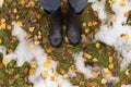 Autumn fall concept with yellow leaves, rain boots and first snow. Change of seasons concept Royalty Free Stock Photo