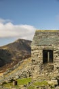 Autumn Fall landscape image of old bothy in Lake Districtr mountains near Buttermere with Haystacks and High Stiel in the distance Royalty Free Stock Photo