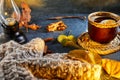 Autumn, fall leaves, a hot steaming cup of coffee and a warm scarf against the background of a blue table. Seasonal, morning Royalty Free Stock Photo