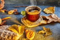 Autumn, fall leaves, a hot steaming cup of coffee and a warm scarf against the background of a blue table. Seasonal, morning Royalty Free Stock Photo