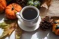 Autumn, fall leaves, hot steaming cup of coffee and a warm scarf on white table background. Seasonal, morning coffee, Sunday Royalty Free Stock Photo