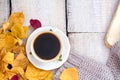 Autumn, fall leaves, hot steaming cup of coffee and a warm scarf on wooden table background.. Royalty Free Stock Photo