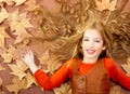 Autumn fall little blond girl on dried tree leaves