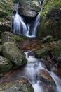 Autumn fall mountain waterfall stream in the rocks with colorful fallen dry leaves, landscape, natural seasonal background Royalty Free Stock Photo